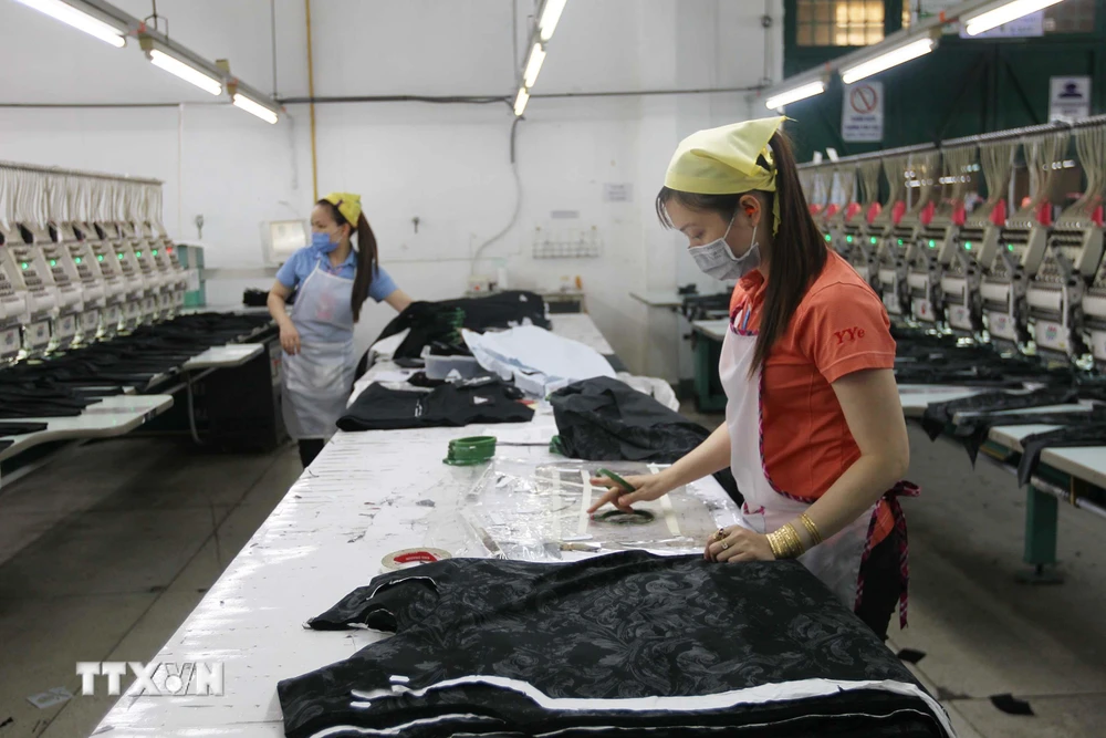 Công nhân Công ty TNHH Thêu Vĩnh Dương (quận Tân Phú) duy trì sản xuất trong những ngày dịch COVID-19. (Ảnh: Thanh Vũ/TTXVN)