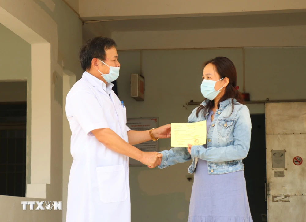 Tiến sỹ-bác sỹ Châu Đương, Giám đốc Bệnh viện Lao và bệnh phổi tỉnh Đắk Lắk trao giấy xuất viện cho bệnh nhân 601. (Ảnh: Tuấn Anh/TTXVN)