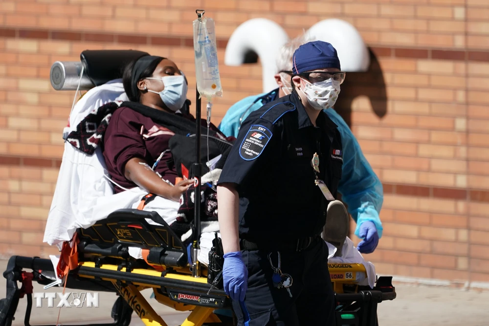 Nhân viên y tế chuyển bệnh nhân mắc COVID-19 vào một bệnh viện ở New York, Mỹ. (Ảnh: AFP/TTXVN)
