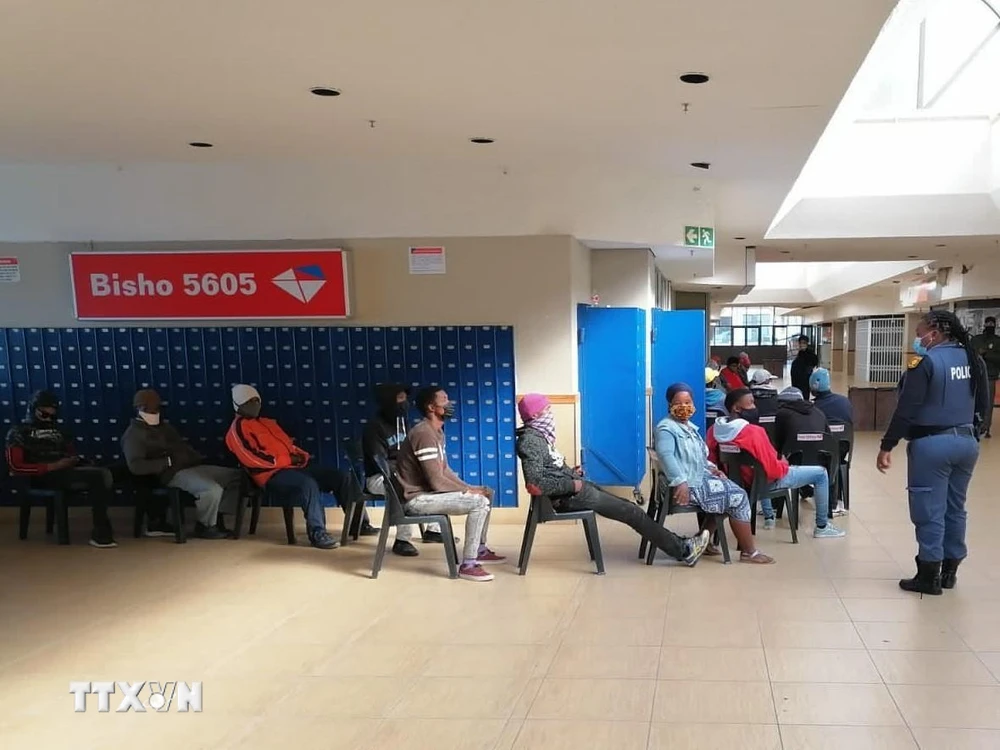 Cảnh sát Nam Phi nhắc nhở người dân thực hiện giãn cách xã hội trong một siêu thị tại thủ đô Pretoria, Nam Phi. (Ảnh: Phi Hùng/TTXVN)