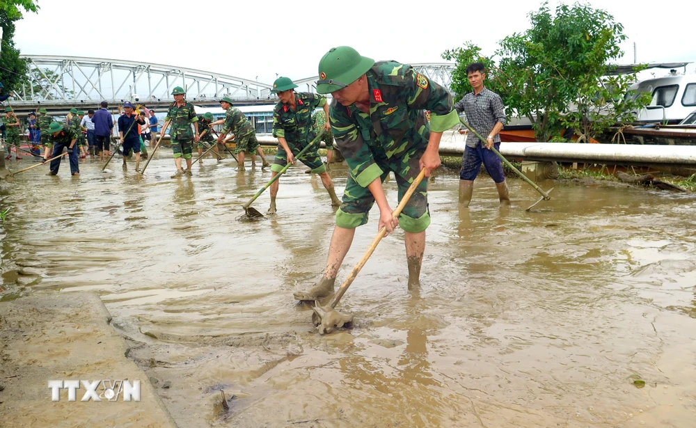 Cán bộ, chiến sỹ cùng người dân khẩn trương dọn vệ sinh sau mưa lũ tại Thừa Thiên-Huế. (Ảnh: Tường Vi/TTXVN)