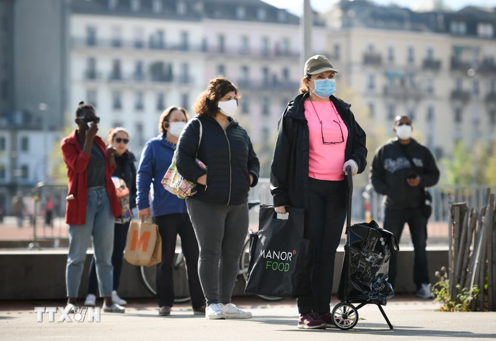 Người dân đeo khẩu trang phòng dịch COVID-19 tại Geneva, Thụy Sĩ. (Ảnh: AFP/TTXVN)
