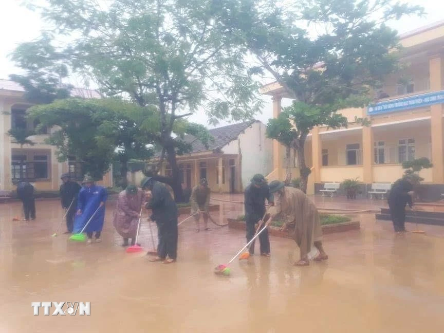 Lực lượng bộ đội cùng người dân tham gia dọn vệ sinh trường THCS Cảnh Hóa, huyện Quảng Trạch (Quảng Bình) để đón học sinh trở lại. (Ảnh: Đức Thọ/TTXVN)