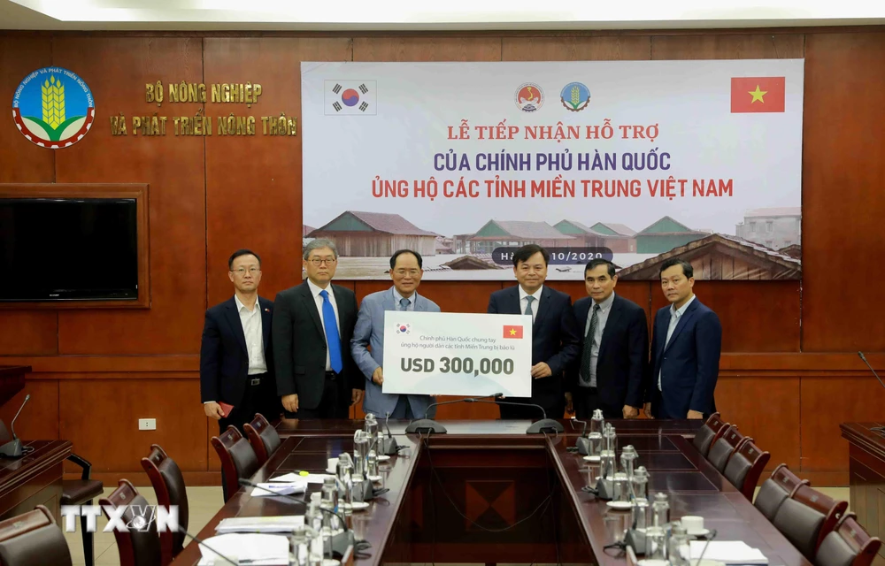 Ông Park Noh-Wan, Đại sứ Hàn Quốc tại Việt Nam trao tượng trưng gói hỗ trợ 300.000 USD cho Ủy viên Ban Chỉ đạo Trung ương về Phòng, chống thiên tai Nguyễn Hoàng Hiệp. (Ảnh: Vũ Sinh/TTXVN)