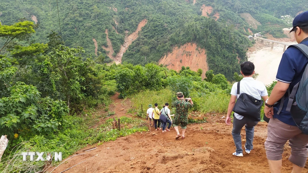 Lực lượng cứu hộ băng rừng Phước Lộc để tiếp cận xã Phước Sơn. (Ảnh: Quốc Dũng/TTXVN)