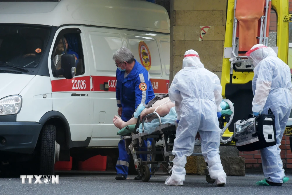 Nhân viên y tế chuyển bệnh nhân mắc COVID-19 lên xe cứu thương tại Saint Petersburg, Nga ngày 5/10/2020. (Ảnh: AFP/TTXVN)