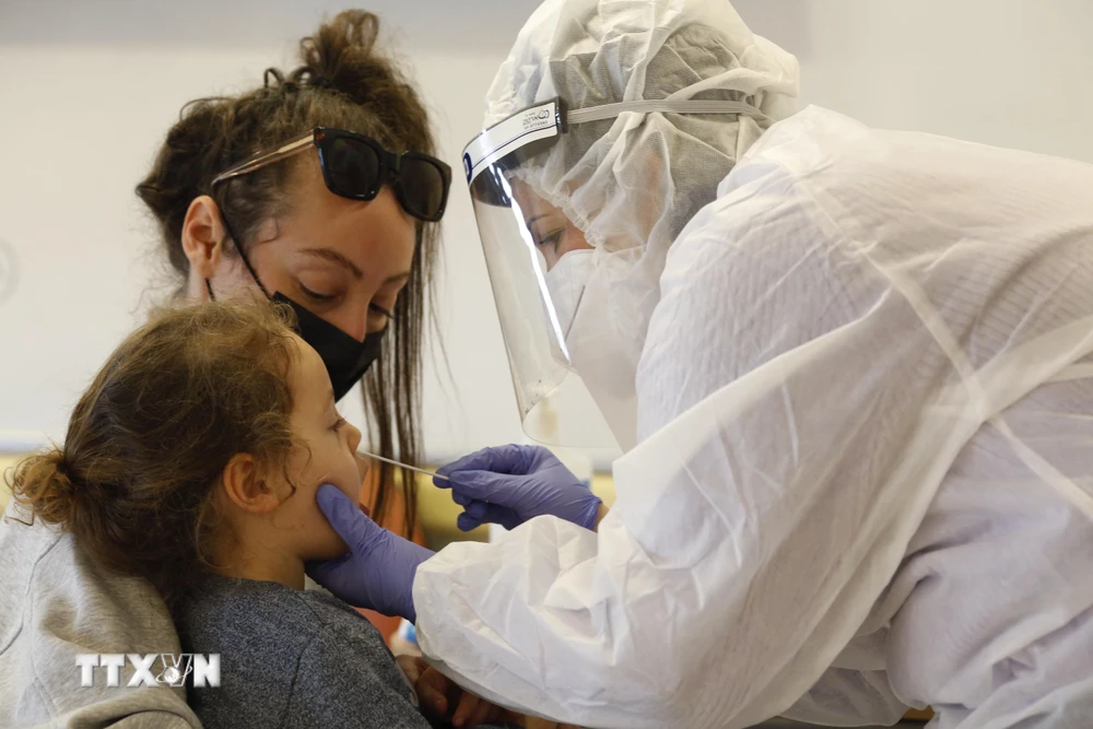 Nhân viên y tế lấy mẫu dịch xét nghiệm COVID-19 cho trẻ em tại Rishon Letzion, Israel, ngày 8/12/2020. (Ảnh: THX/TTXVN)