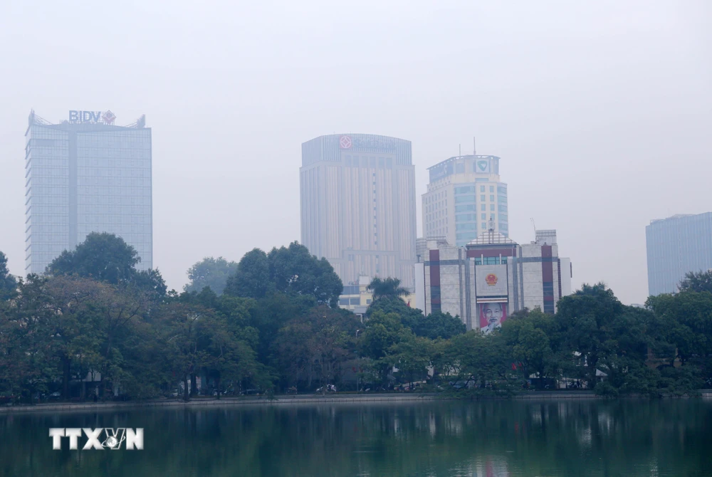 Các tòa nhà cao tầng chìm trong lớp sương mù, bụi mịn (ảnh chụp lúc 10h10 khu vực hồ Hoàn Kiếm). (Ảnh: Hoàng Hiếu/TTXVN)