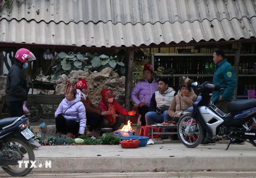 Tại phường Thanh Trường (thành phố Điện Biên Phủ), nhiều tiểu thương tụ tại điểm chợ cóc cạnh quốc lộ 12 tập sưởi ấm bên đống lửa. (Ảnh: Xuân Tiến/TTXVN)