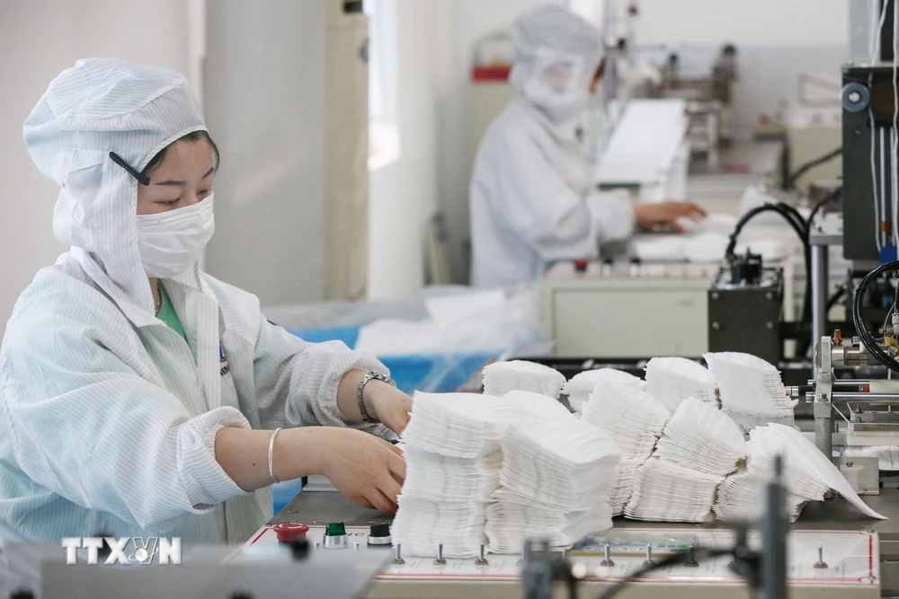 Công nhân sản xuất khẩu trang tại một nhà máy ở tỉnh Giang Tô, miền đông Trung Quốc, ngày 14/5/2020. (Ảnh: AFP/TTXVN)