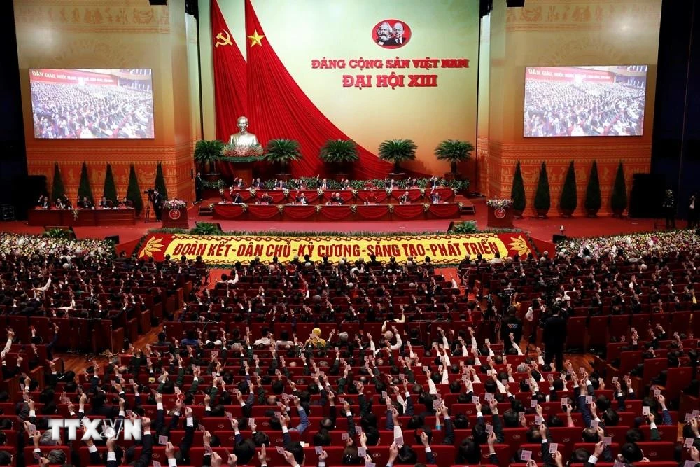 Các đại biểu biểu quyết, thông qua Nghị quyết Đại hội XIII Đảng Cộng sản Việt Nam. (Ảnh: TTXVN)