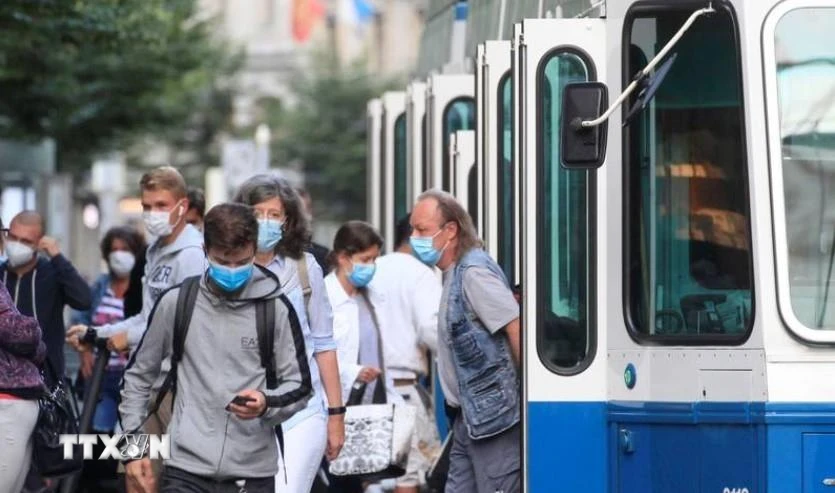 Người dân đeo khẩu trang phòng dịch COVID-19 khi sử dụng phương tiện lưu thông công cộng tại Zurich, Thụy Sĩ. (Ảnh: Reuters/TTXVN)