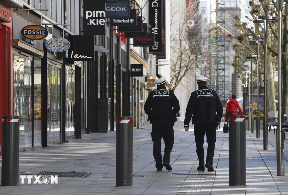 Nhân viên an ninh tuần tra gần Koeniggstrasse, một khu phố thương mại sầm uất ở Stuttgart, miền Nam Đức trong bối cảnh lệnh hạn chế được ban bố do dịch COVID-19. (Ảnh: AFP/TTXVN)