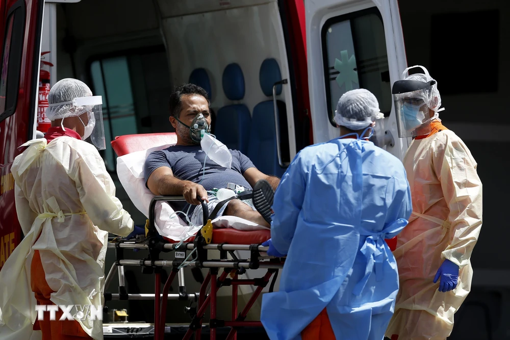 Nhân viên y tế chuyển bệnh nhân COVID-19 từ xe cứu thương vào một bệnh viện ở Brasilia, Brazil ngày 25/3/2021. (Ảnh: THX/TTXVN)