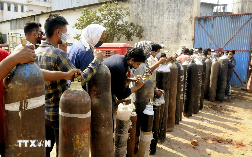 Người dân xếp hàng chờ bơm đầy bình oxy để cung cấp cho bệnh nhân COVID-19 tại Patna, Ấn Độ, ngày 27/4/2021. (Ảnh: THX/TTXVN)