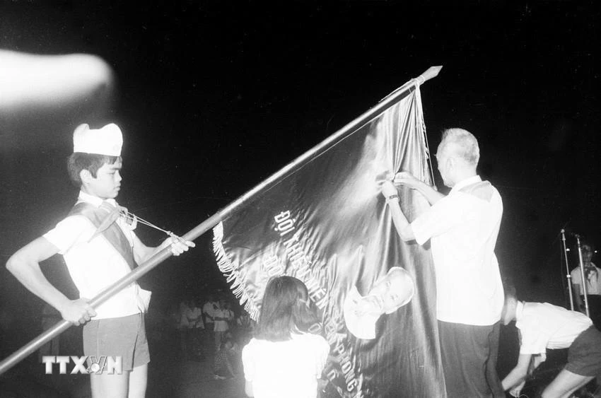 Quyền Chủ tịch Nguyễn Hữu Thọ gắn Huân chương Hồ Chí Minh lên lá cờ truyền thống của Đội Thiếu niên Tiền phong Hồ Chí Minh (1981). (Ảnh: Ngọc Quán/TTXVN)