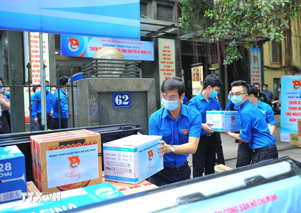 Ông Bùi Quang Huy, Bí thư Thường trực Trung ương Đoàn, Chủ tịch Trung ương Hội Sinh viên Việt Nam vận chuyển hàng lên xe để chuyển đến cho các lực lượng phòng, chống COVID-19 tuyến đầu tại Bắc Giang. (Ảnh: Minh Đức/TTXVN)