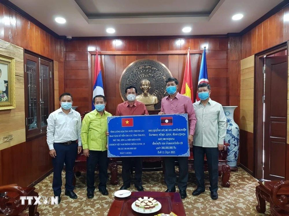 Đại diện chính quyền tỉnh Luang Namtha, Lào trao tặng tiền hỗ trợ 4 tỉnh của Việt Nam phòng chống dịch bệnh covid-19. (Ảnh: TTXVN phát)