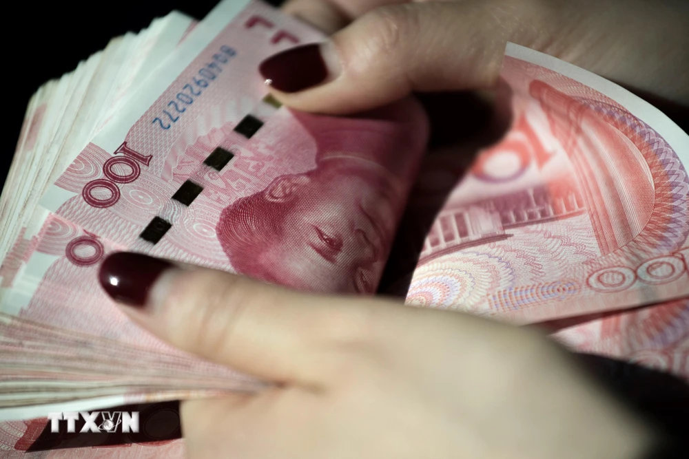 Đồng tiền giấy mệnh giá 100 Nhân dân tệ ở Bắc Kinh, Trung Quốc. (Ảnh: AFP/TTXVN)