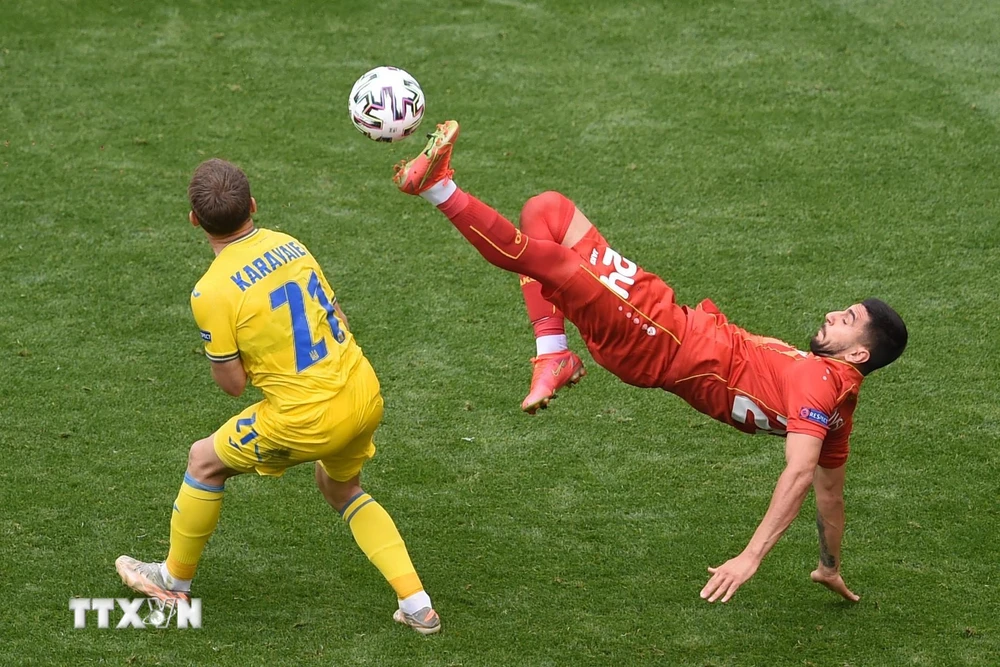 Pha tranh bóng giữa cầu thủ Bắc Macedonia Daniel Avramovski (phải) và Oleksandr Karavaev của Ukraine trong trận đấu bảng C, Vòng chung kết EURO 2020, tại Bucharest, Romania, ngày 17/6/2021. (Ảnh: AFP/TTXVN)