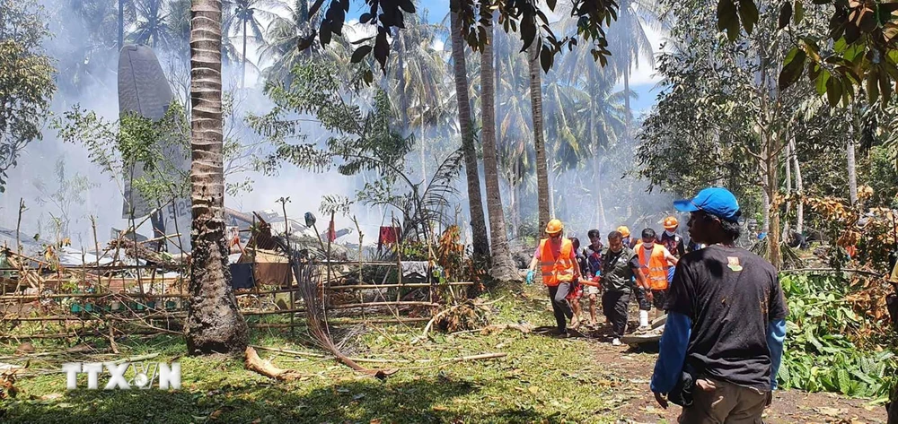 Nhân viên cứu hộ làm nhiệm vụ tại hiện trường vụ máy bay rơi gần sân bay trên đảo Jolo, Sulu, Philippines ngày 4/7/2021. (Ảnh: AFP/TTXVN)