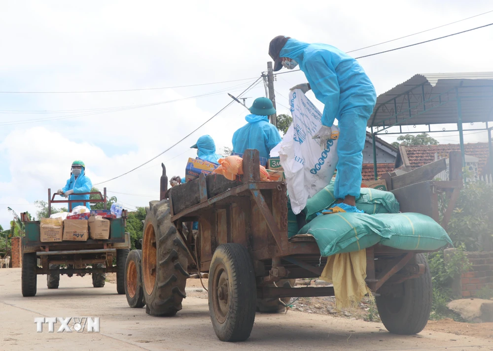 Thầy Ksor Y Chét, sinh năm 1984, giáo viên Trường Tiểu học, Trung học cơ sở Ea Trol, huyện Sông Hinh (đầu tiên bên phải) cùng cộng sự vận chuyển nhu yếu phẩm hỗ trợ bà con hai buôn Ly và buôn Bầu, xã Ea Trol. (Ảnh: Phạm Cường/TTXVN)