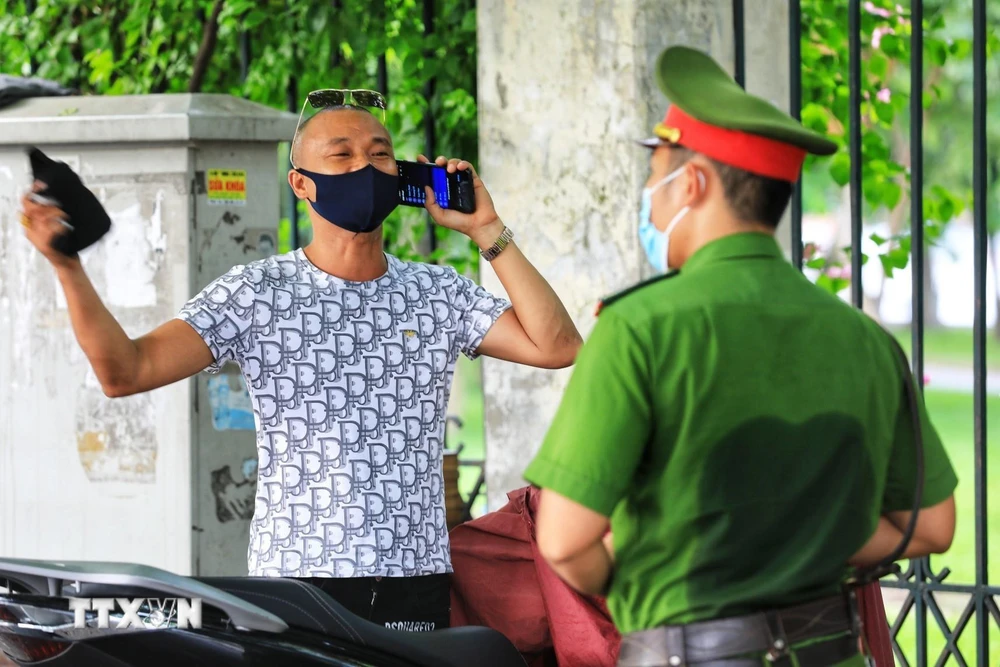 Công an phường Lê Đại Hành, Hà Nội xử lý nghiêm trường hợp ra đường không có việc thiết yếu sau nhiều lần đã nhắc nhở. (Ảnh: Thành Đạt/TTXVN)