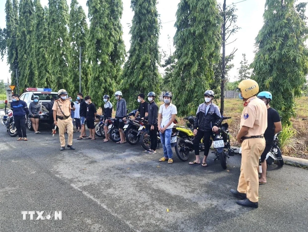 Các “quái xế” cùng phương tiện tụ tập đua xe, cổ vũ đua tại Khu công nghiệp Biên Hòa 2 bị tạm giữ ngày 4/7. (Ảnh: TTXVN phát)