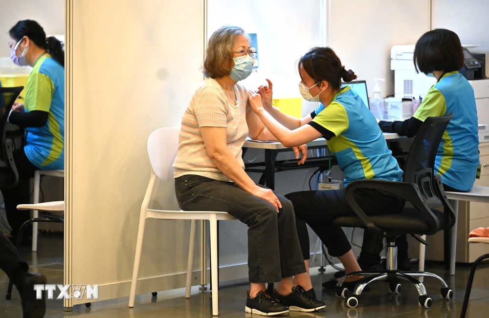 Trong ảnh: Nhân viên y tế tiêm chủng vaccine ngừa COVID-19 cho người dân tại Hong Kong, Trung Quốc. (Ảnh: AFP/TXVN)