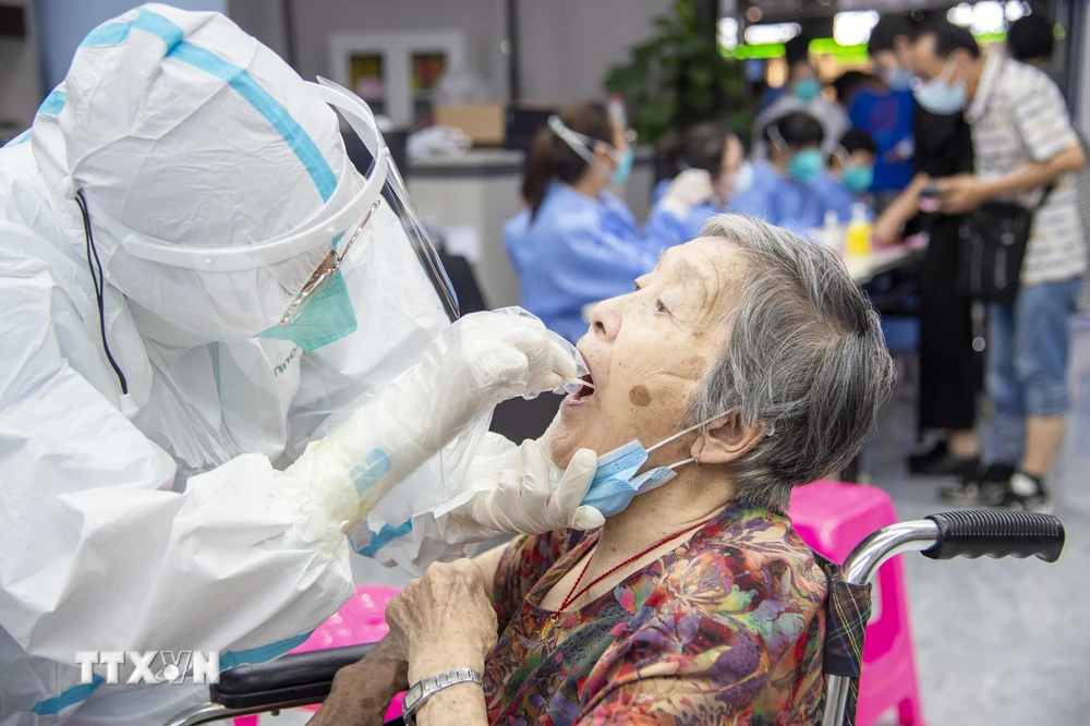 Nhân viên y tế lấy mẫu xét nghiệm COVID-19 cho người dân tại Vũ Hán, Trung Quốc, ngày 3/8/2021. (Ảnh: THX/TTXVN)