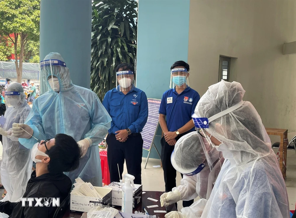 Nhân viên y tế lấy mẫu test nhanh "quét" F0 trên địa bàn thành phố Dĩ An (Bình Dương). (Ảnh: TTXVN phát)