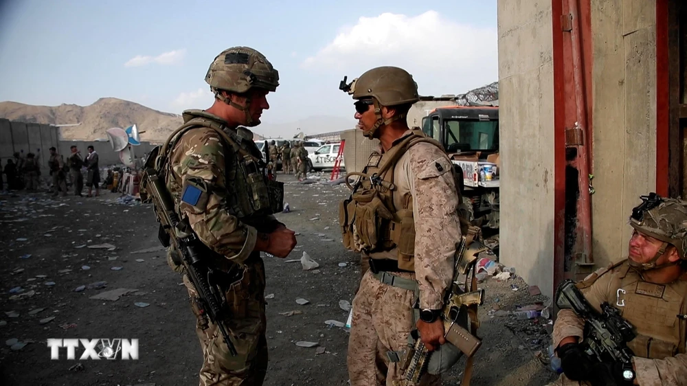 Binh sỹ Anh và binh sĩ Mỹ gác tại khu vực sân bay Kabul, Afghanistan, ngày 22/8/2021. (Ảnh: AFP/TTXVN)