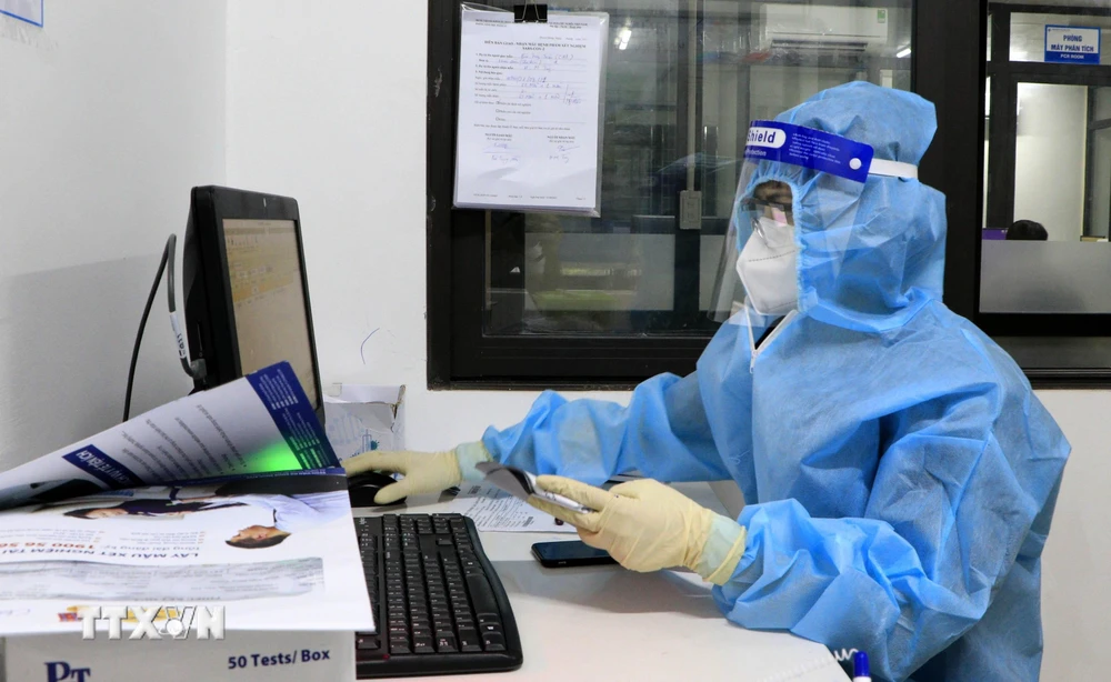 Các bác sỹ Bệnh viện Đa khoa tư nhân Hùng Vương làm xét nghiệm trên hệ xét nghiệm SARS-CoV-2. (Ảnh: Trung Kiên/TTXVN)