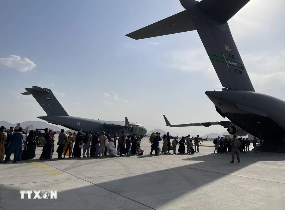 Người dân xếp hàng lên máy bay quân sự của Mỹ ở sân bay quốc tế Kabul (Afghanistan), để rời khỏi quốc gia Tây Nam Á, ngày 22/8/2021. (Ảnh: THX/TTXVN)