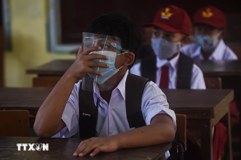 Học sinh đeo khẩu trang phòng lây nhiễm COVID-19 trong ngày đầu tiên quay lại trường học sau nhiều tháng do dịch bệnh COVID-19 tại Tây Java, Indonesia, ngày 6/9/2021. (Ảnh: THX/TTXVN)