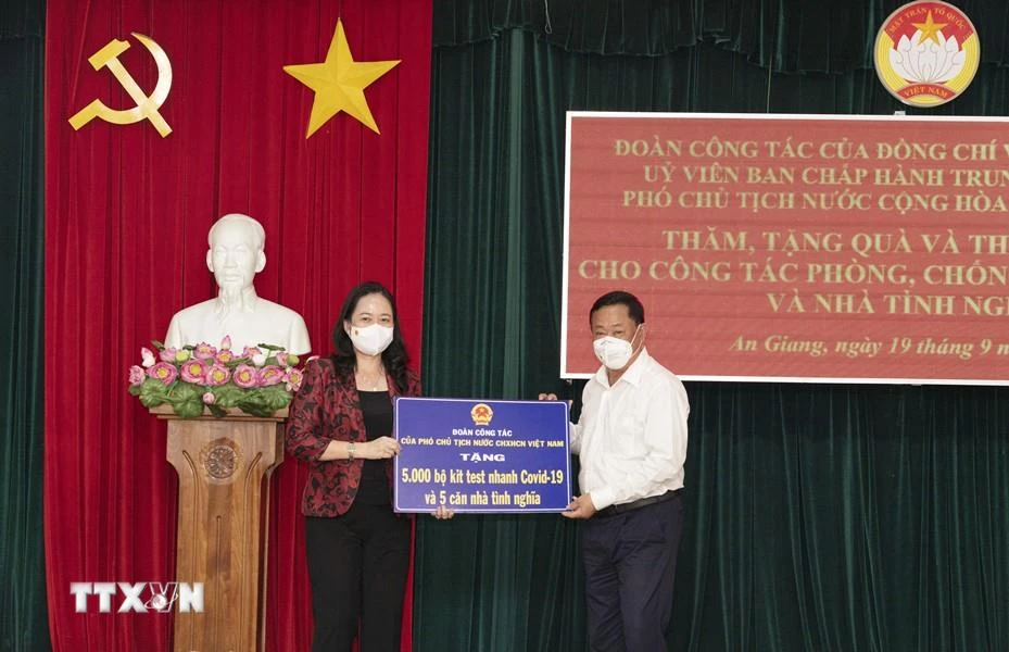 Phó Chủ tịch nước Võ Thị Ánh Xuân trao bảng tượng trưng 5.000 bộ kit test nhanh COVID-19 và 5 căn nhà tình nghĩa cho tỉnh An Giang. (Ảnh: Công Mạo/TTXVN)