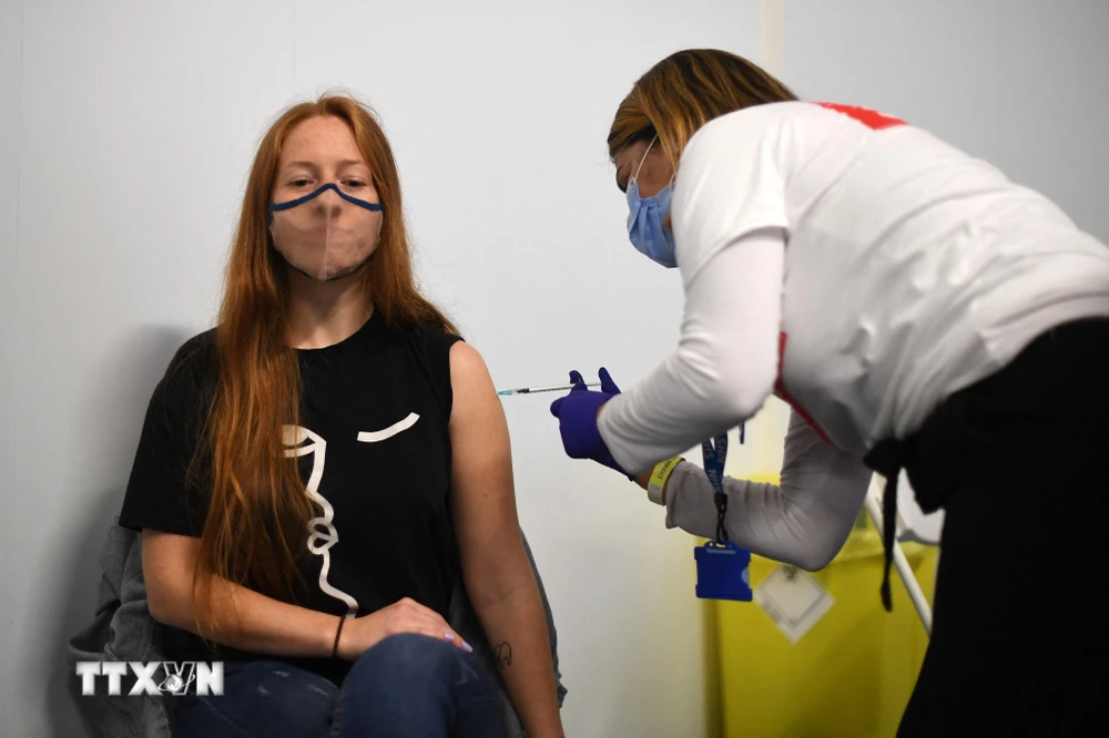 Nhân viên y tế tiêm vaccine ngừa COVID-19 của hãng Pfizer cho người dân tại London. (Ảnh: AFP/TTXVN)