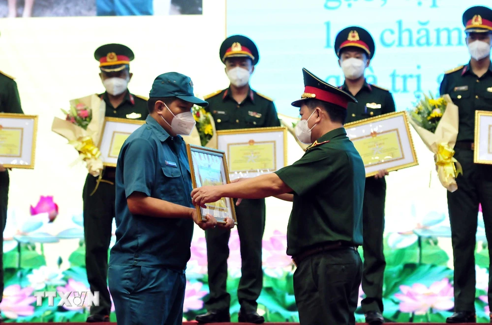 Thiếu tướng Phan Văn Xựng (phải), Chính ủy Bộ Tư lệnh Thành phố Hồ Chí Minh, trao tặng Bằng khen cho các cá nhân điển hình có thành tích xuất sắc trong công tác phòng, chống dịch COVID-19. (Ảnh: Xuân Khu/TTXVN)
