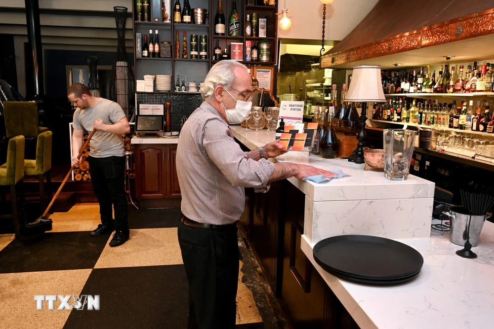Một nhà hàng tại thành phố Melbourne, Australia chuẩn bị cho việc mở cửa trở lại, ngày 21/10/2021. (Ảnh: AFP/TTXVN)