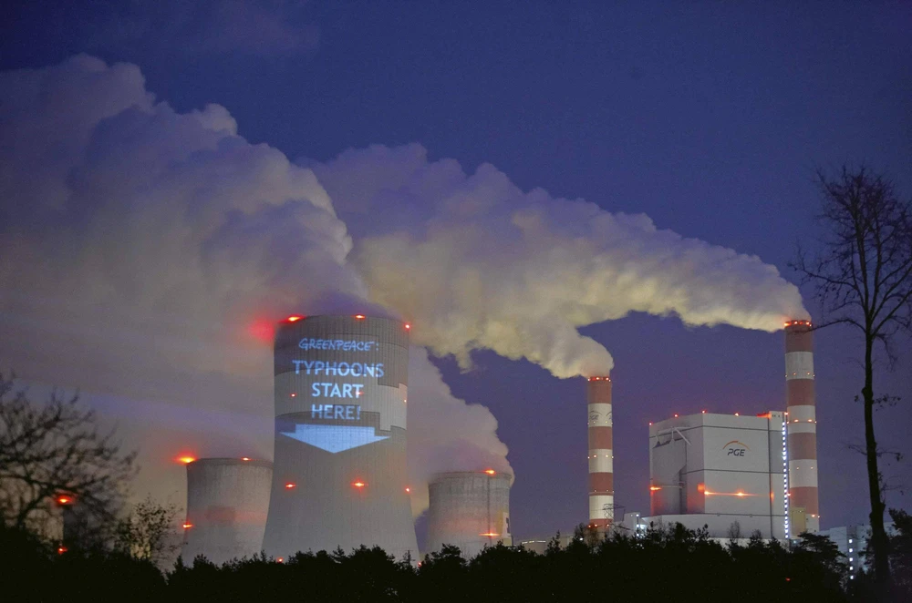 Một khẩu hiệu được các nhà hoạt động chiếu sáng lên tháp làm mát của Nhà máy điện Belchatow, nhà máy nhiệt điện than lớn nhất châu Âu, ở Ba Lan vào tháng 11/2013. (Nguồn: Reuters)