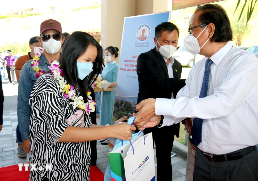 Tặng quà lưu niệm những du khách đầu tiên đến Bình Thuận trong giai đoạn bình thường mới tại Centara Mirage Resort (thành phố Phan Thiết). (Ảnh: Nguyễn Thanh/TTXVN)