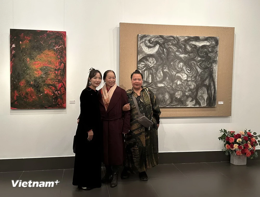 Nữ họa sỹ Nguyễn Trần Thảo Nguyên (bìa trái) và khách tham quan tại Triển lãm. (Ảnh: CTV/Vietnam+)