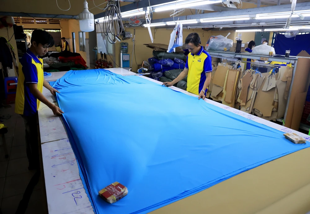 Cắt may tại xưởng gia công dệt may xuất khẩu Công ty TNHH May mặc Dony, xã Vĩnh Lộc A, huyện Bình Chánh, Thành phố Hồ Chí Minh. (Ảnh: Hồng Đạt/TTXVN)