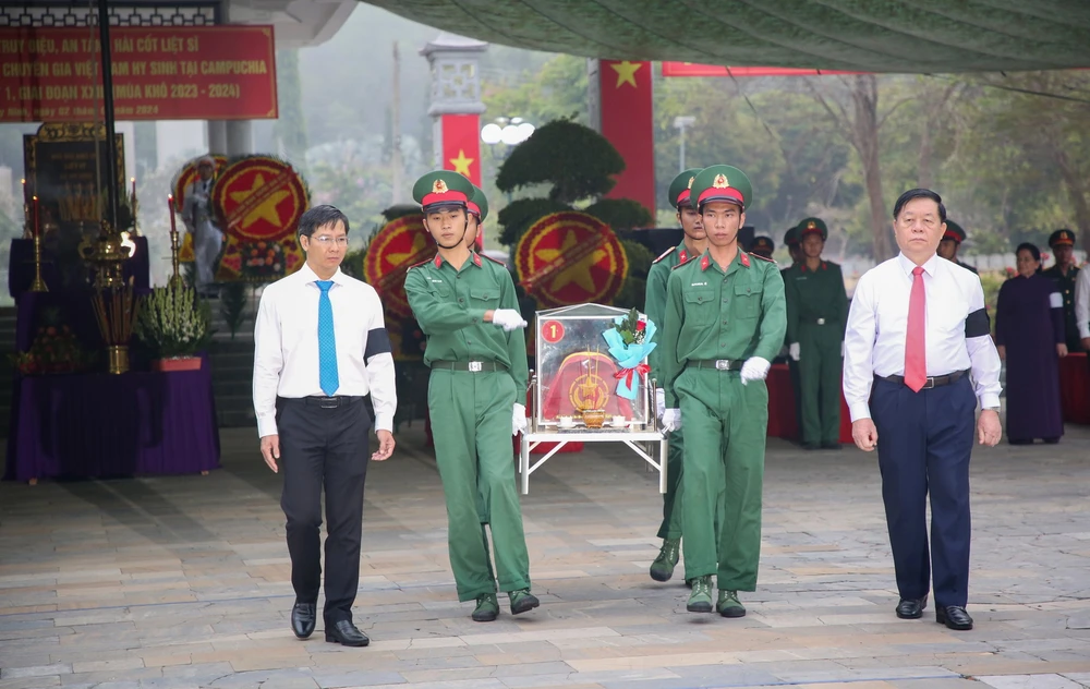 Trưởng Ban Tuyên giáo Trung ương Nguyễn Trọng Nghĩa (phải) và Bí thư Tỉnh ủy, Chủ tịch HĐND tỉnh Tây Ninh Nguyễn Thành Tâm (trái) di an hài cốt liệt sỹ đến nơi an táng. (Ảnh: Giang Phương/TTXVN)