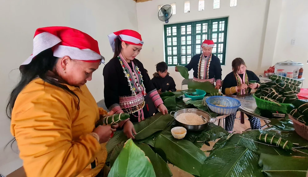 Tạm gác lại những bộn bề lo âu của cuộc sống, người dân xã Liên Minh quây quần gói bánh chưng chuẩn bị đón Tết Nguyên đán Giáp Thìn. (Ảnh: Hương Thu/TTXVN)