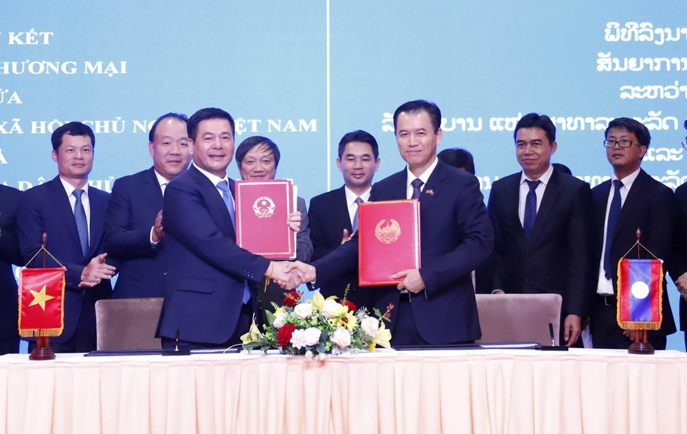 Bộ trưởng Bộ Công Thương Nguyễn Hồng Diên và Bộ trưởng Bộ Công Thương Lào Malaithong Kommasith ký Hiệp định thương mại Việt Nam-Lào. (Ảnh: Phạm Kiên/TTXVN)
