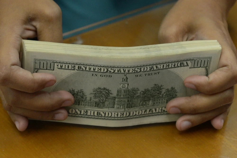 Đồng tiền mệnh gi&aacute; 100 USD. (Ảnh: AFP/ TTXVN)