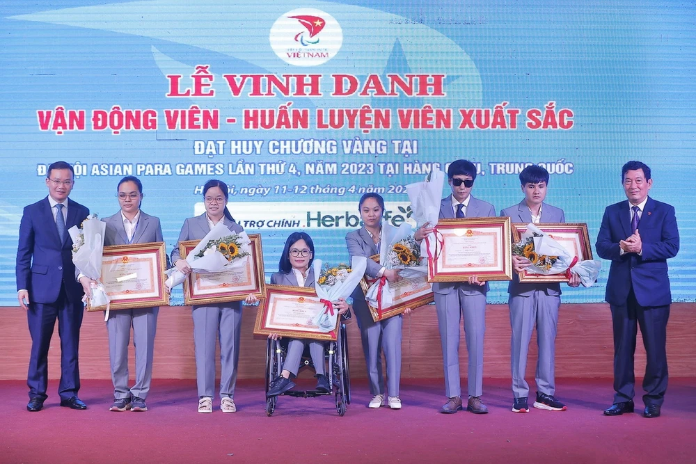 Trao Bằng khen của Thủ tướng Chính phủ cho 6 vận động viên có thành tích thi đấu xuất sắc tại Đại hội thể thao người khuyết tật Châu Á lần thứ 4 tại Hàng Châu, Trung Quốc. (Ảnh: Minh Quyết/TTXVN)