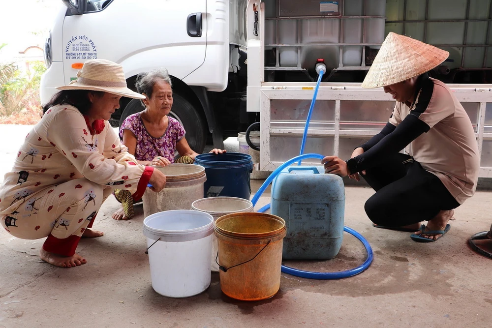 Người dân đến lấy nước tại điểm cấp nước ấp Pháo Đài, xã Phú Tân. (Ảnh: Minh Trí/TTXVN)