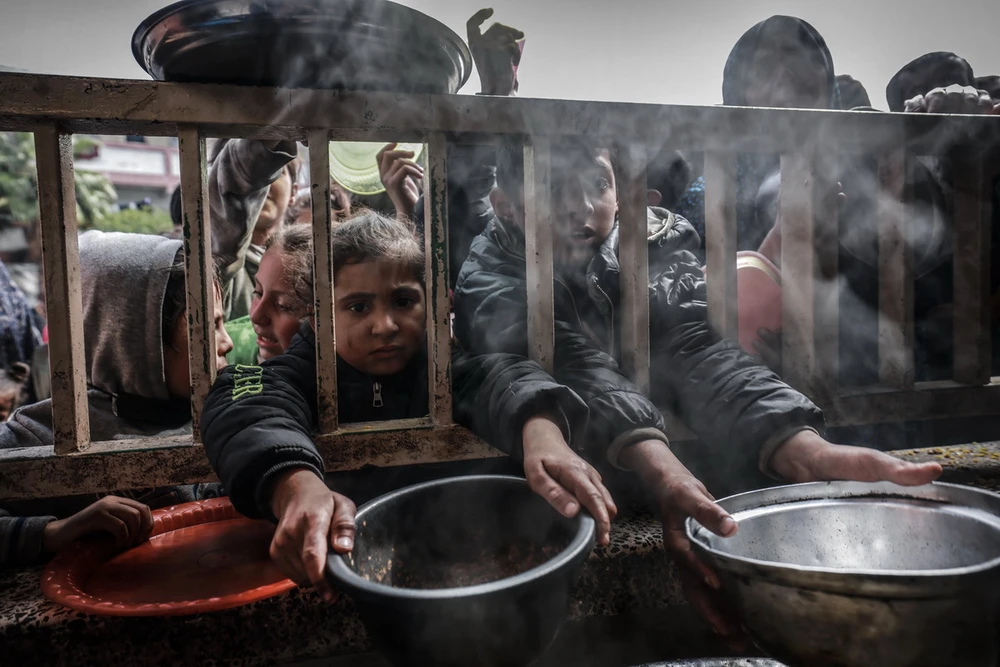 Trẻ em Palestine chờ nhận thức ăn cứu trợ ở thành phố Rafah, miền Nam Dải Gaza, trong bối cảnh xung đột Israel-Hamas tiếp diễn, ngày 19/4/2024. (Ảnh: AFP/TTXVN)